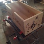 custom designed cello stand with engraved music sybols